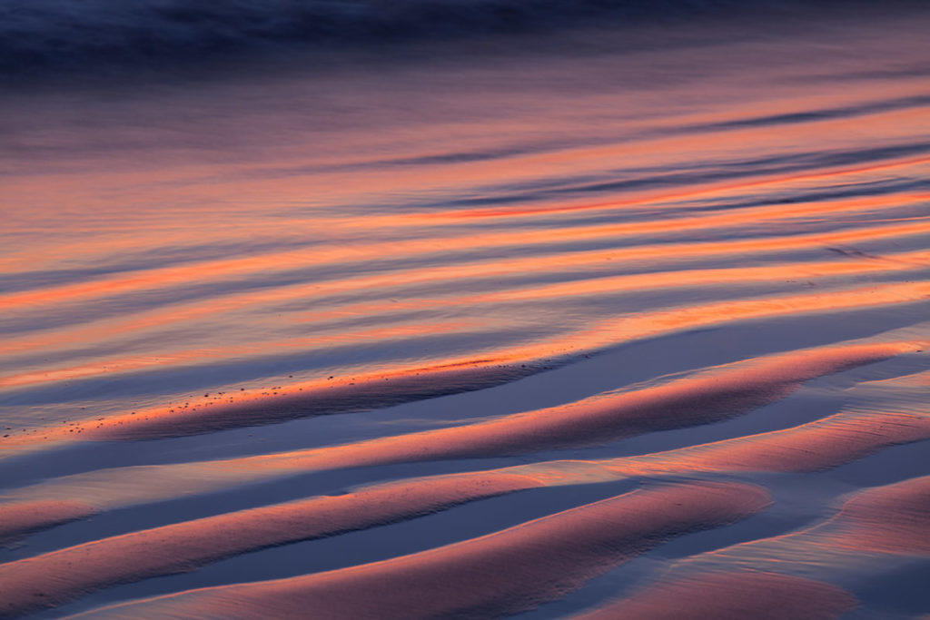 ripples in beach sand at sunset