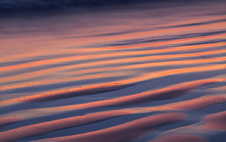 ripples in beach sand at sunset