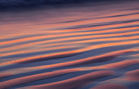 ripples in beach sand at sunset