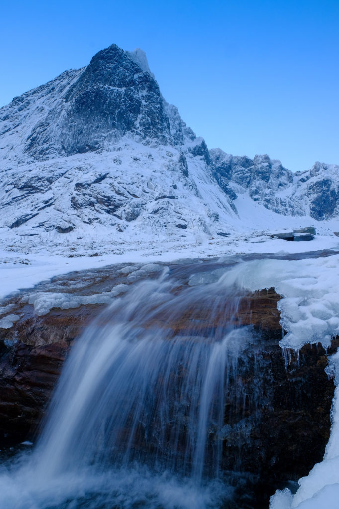 Snow covered mountain with waterfall
