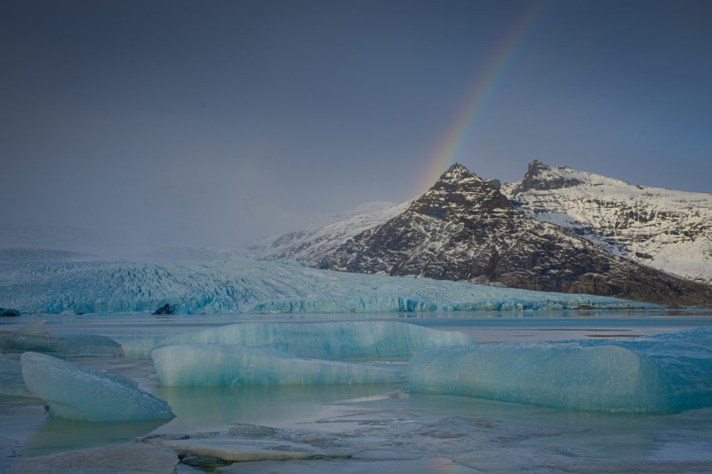 Mountains and iceberg and rainbow over lagoon in Iceland photo workshop
