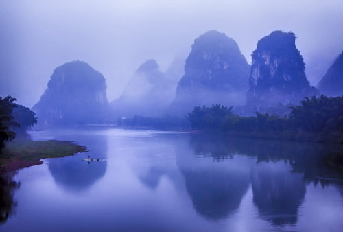 river and mountains in fog in china