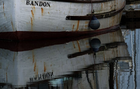 fishing boat reflected in the calm water