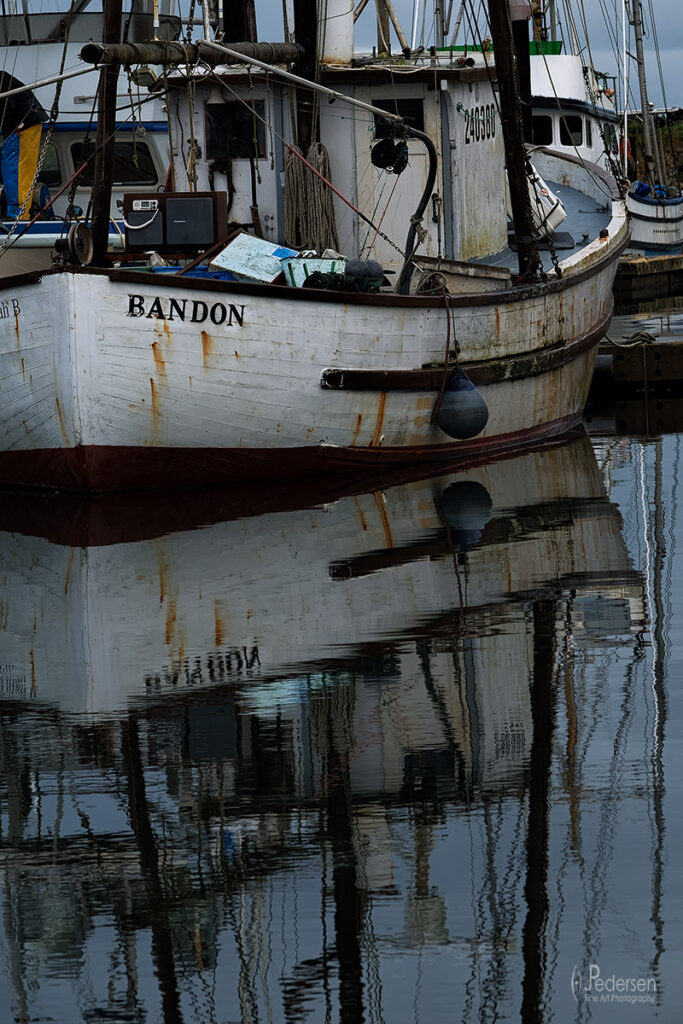 fishing boat reflected in the calm water