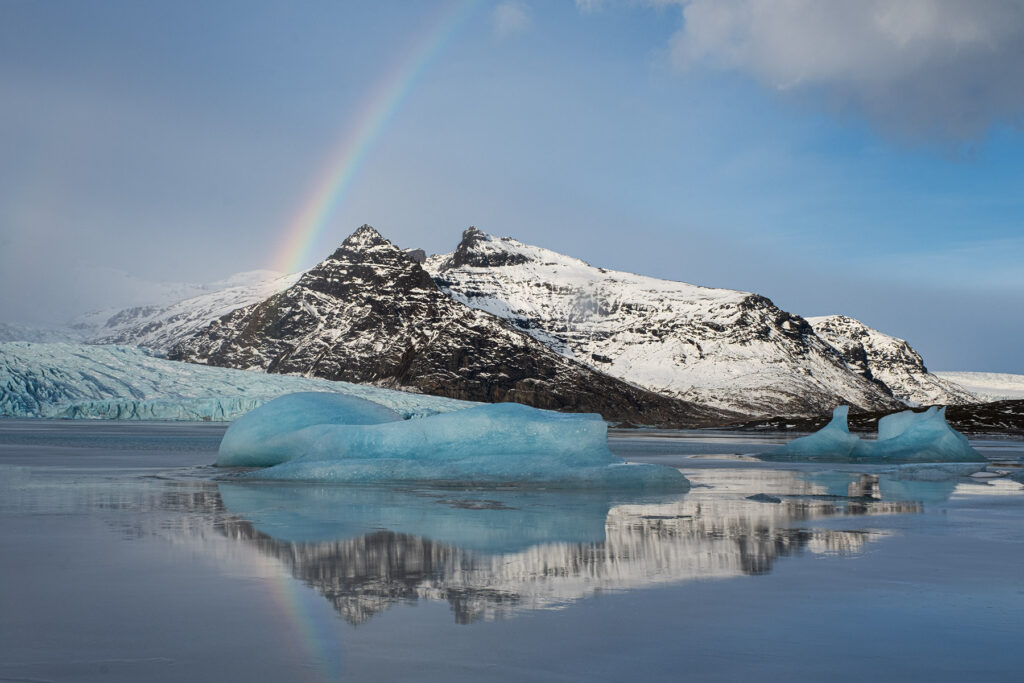 mountains and glacial lagoon with a rainbow in Iceland