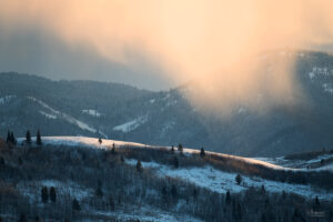 Golden sunlight illuminates snow clouds in Wyoming in winter
