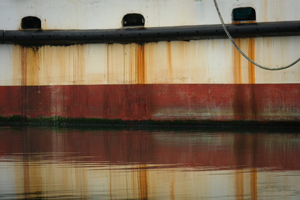 Rust and paint reflected in calm waters in Newport Oregon