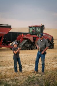 Grandpa and grandson taking a break from harvesting wheat fields