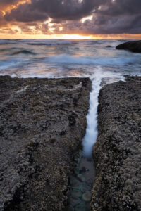 Waves crash along the oregon coast at sunset