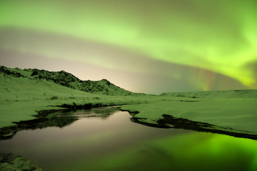 The northern lights over a small creek in Iceland