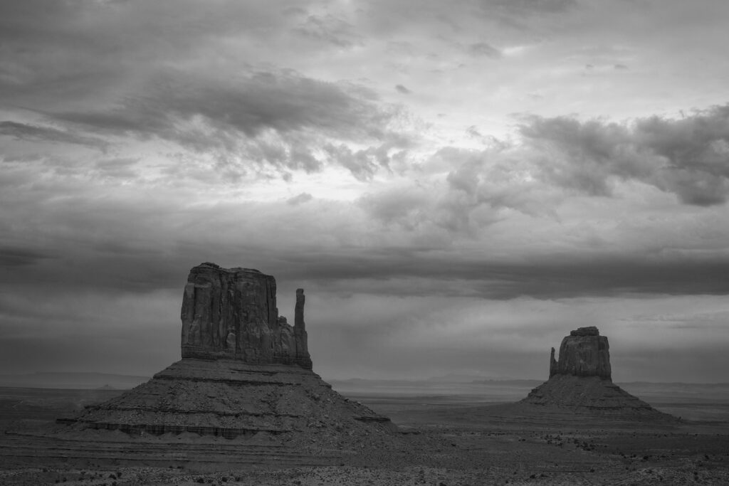 A monochrome image of the Mittens in Monument Valley