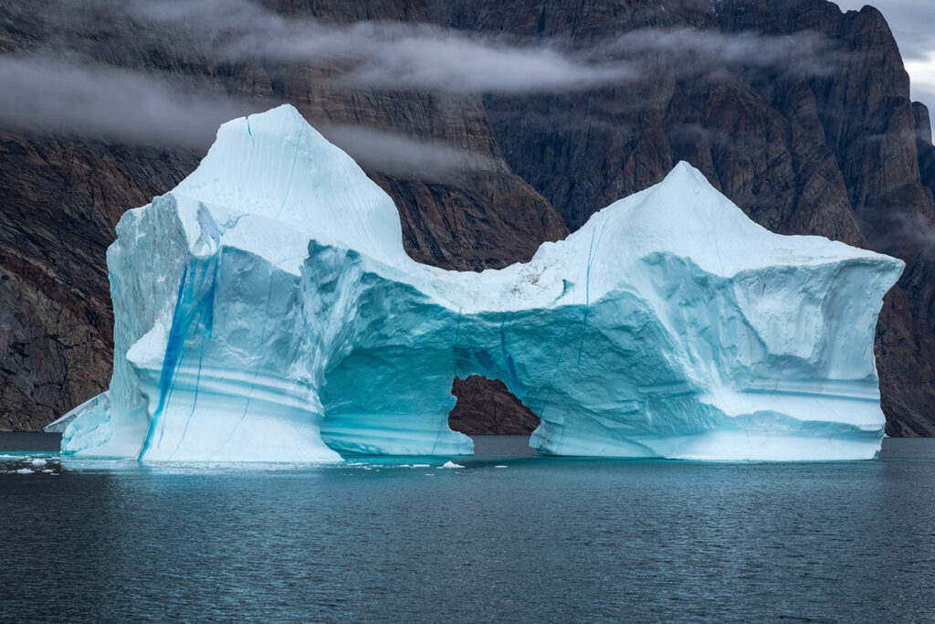 Iceberg with arch inside in Greenland