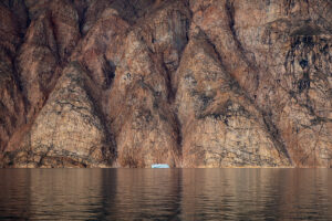 Orange rocks and iceberg in Greenland