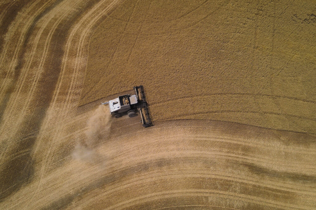 Aerial photo of a combining harvesting a wheat field